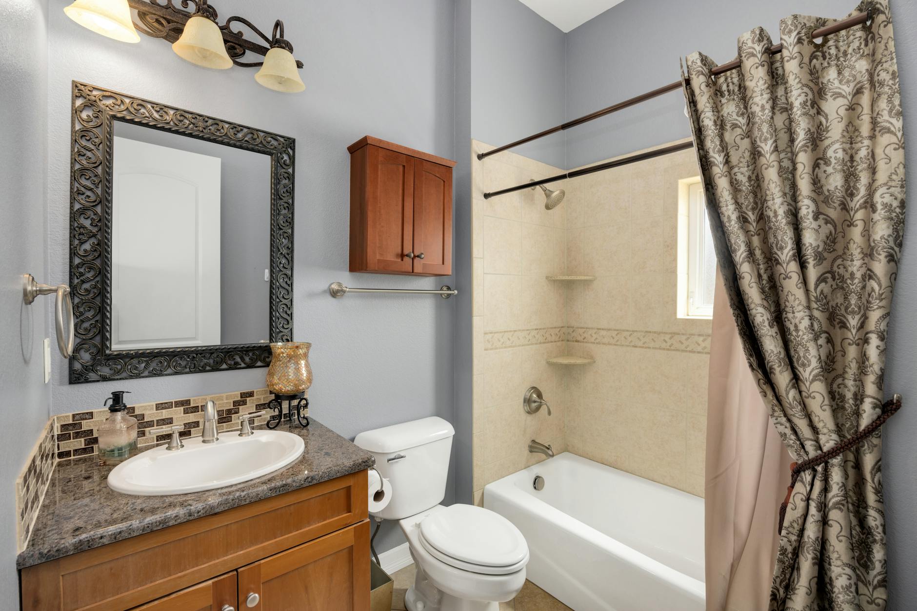 Elegancka łazienka z nowoczesną zabudową meblową i dużym lustrem