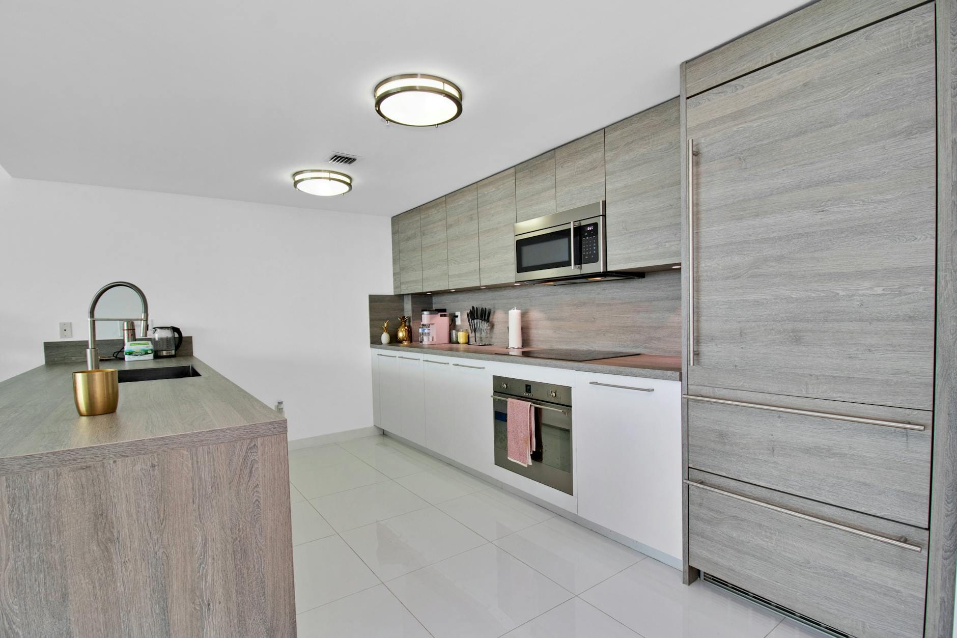 Nowoczesna kuchnia z białymi szafkami wiszącymi i drewnianymi akcentami