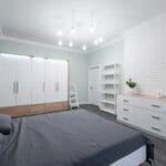 Nowoczesna sypialnia z białymi meblami i łóżkiem w minimalistycznym stylu