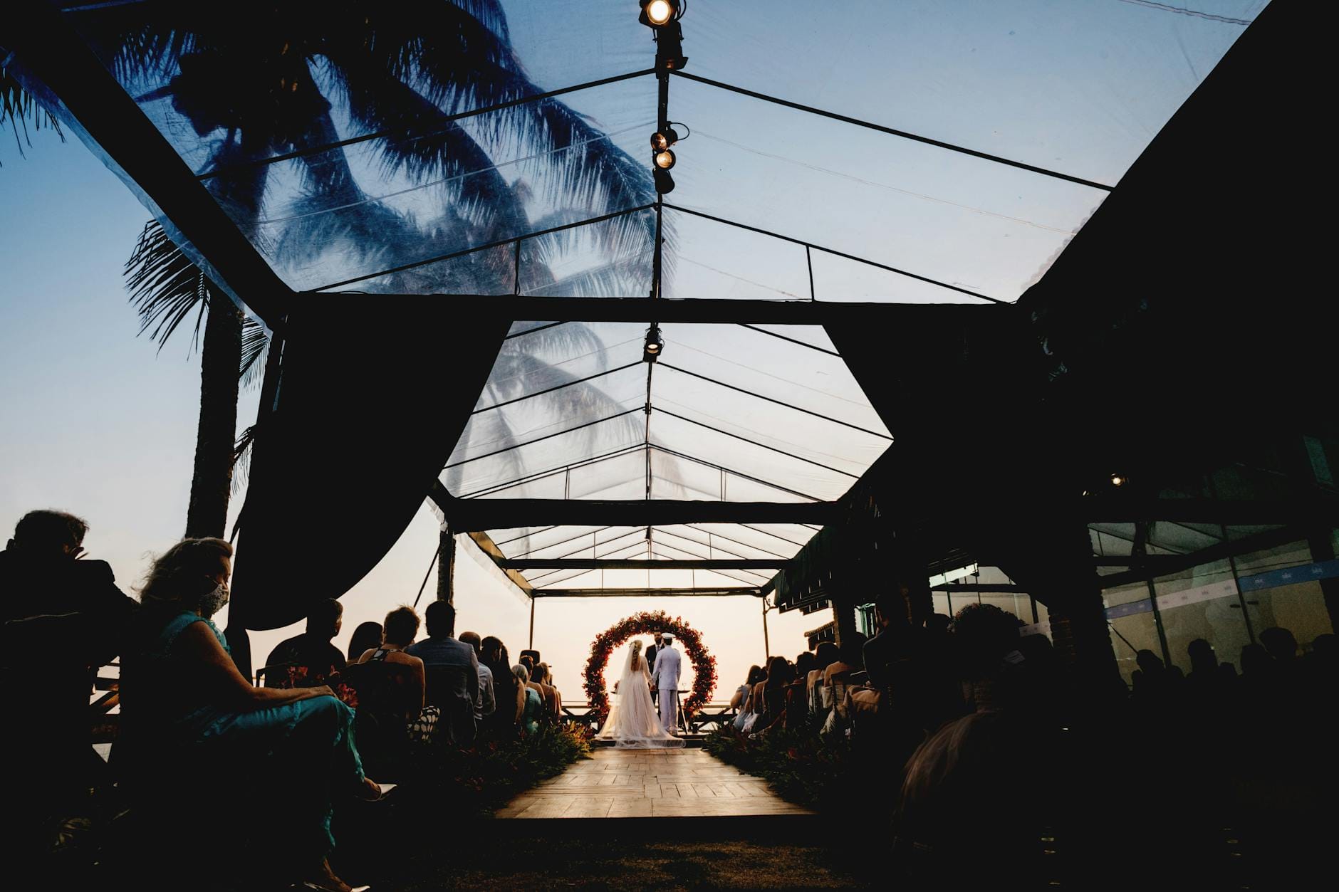 Wieczorna ceremonia ślubna pod szklanym namiotem wśród zieleni